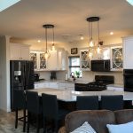 a kitchen with white cabinets and black appliances