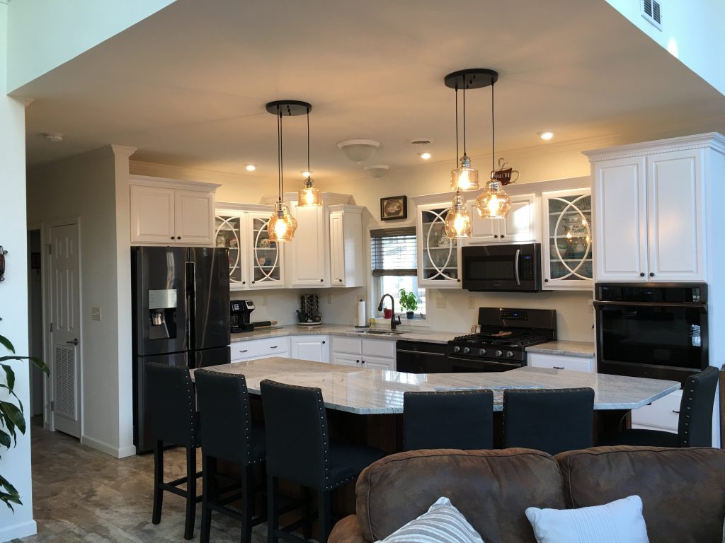 A kitchen with white cabinets and black appliances.