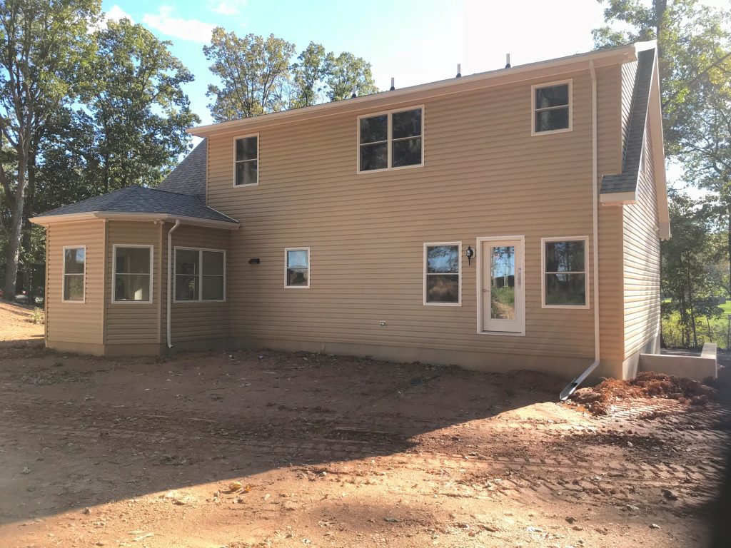 The back of a house with a lot of windows.