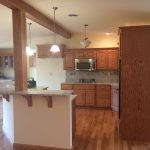 A kitchen with wooden cabinets , a microwave , and a refrigerator .