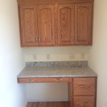 A kitchen with wooden cabinets and a granite counter top .