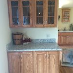 A kitchen with wooden cabinets and a granite counter top.