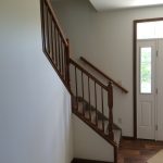 a hallway with stairs and a door in a house .