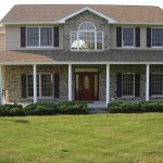 a large brick house with a large lawn in front of it .